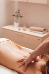 Obraz na płótnie Canvas Masseur hands massaging female back free space. Nude woman relaxing at spa salon, having treating procedures. Beauty, health, body care, weight loss, rest, pleasure, craftmanship concept
