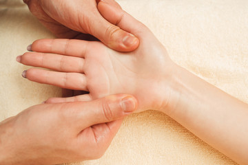 Female palm massaging flat lay closeup. Top view on masseur hand beating female hand and fingers. Health care, osteopathy, whole body massage, relax concept