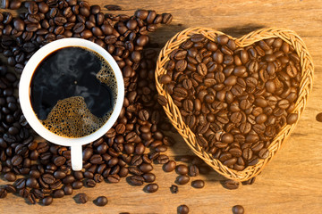white cup of coffee and coffee bean on wood texture,top view