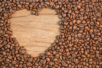 heart shape of coffee bean on wooden,top view