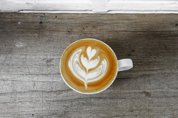 cup of latte art coffee on wooden background