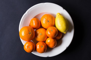 various types of citrus fruit on a dark background