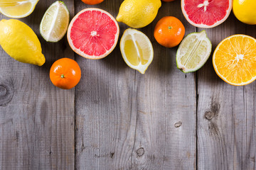 various types of citrus fruit on a wooden background
