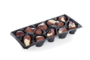 Tray of Belgian bonbons shaped as seashells isolated on white background