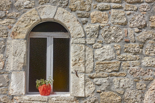 arched window on stone wall, Hydra island, Greece. Space for typing