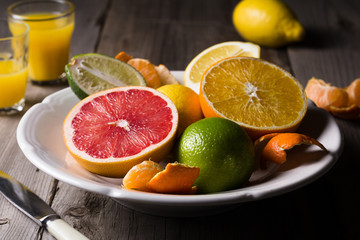 various types of citrus fruit on a dark wooden background