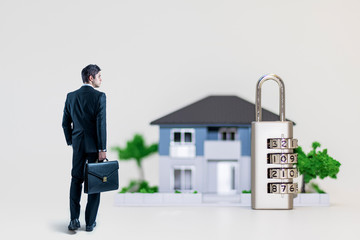 businessman and dial lock in front of house, abstract concept of home security