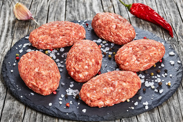 Fototapeta na wymiar fresh ground raw meat cutlets on slate plate