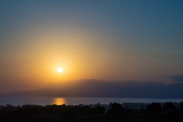 Hersonissos foggy sunrise with sun glade, Crete, Greece.