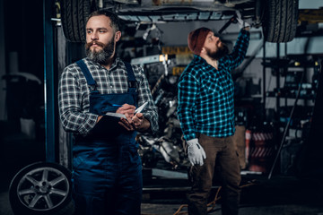 Obraz na płótnie Canvas Two mechanics in a garage.