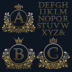 Vintage monogram kit. Golden patterned letters and floral coat of arms frames for creating initial logo in antique style.