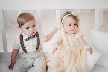 two babies wedding - boy and girl dressed as bride and groom