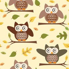 Seamless pattern with owls on a tree branch and autumn leaves on a yellow background