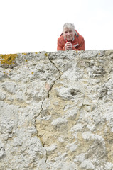 eine frau blickt über eine mauer