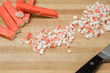 Crab sticks on the wooden board in the kitchen. Healthy eating and lifestyle.