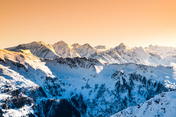 Winter snowy peaks of Alps. Mountain panorama illuminated by sunset at evening time. Austria and...