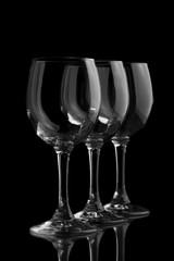 Three elegant wine glasses in a black background.