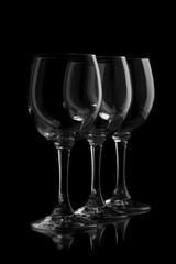 Three elegant wine glasses in a black background.