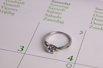 Engagement ring on calendar page. Love, Wedding, Marriage concept.