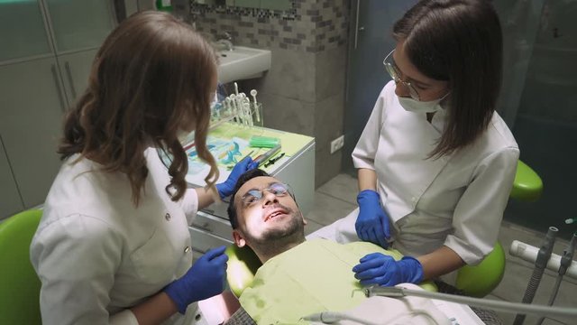 Dentists communicate with a man after a dental examination. 4k footage. Dental clinic. Close-up.
