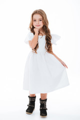 Pretty charming little girl in dress standing and posing
