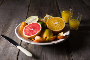 various types of citrus fruit on a dark wooden background
