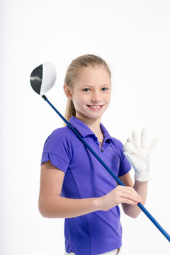 Pretty girl golfer posing with golf club and ball on white backgroud in studio