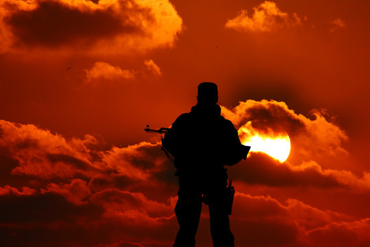 silhouette of a soldier with a gun in the sunset