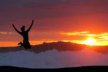 beautiful silhouette of a girl jumping at sunset