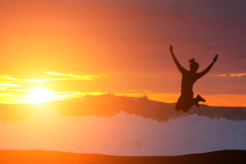 beautiful silhouette of a girl jumping at sunset