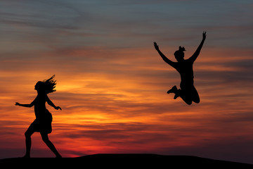 Fototapeta na wymiar Two beautiful silhouette of a girl jumping at sunset