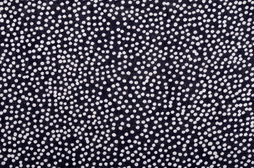 Polka dots on dark blue fabric as background.