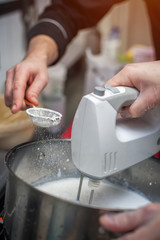 Preparing cream with sugar powder, closeup