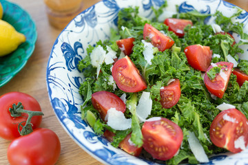 Bowl of Kale and Tomato Salad with Parmesan Cheese Shavings.