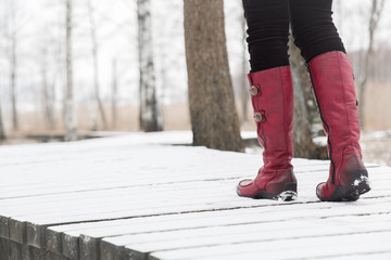 Woman walking in winter day. Winter boots on legs. Active lifestyle at nature.