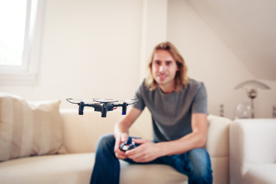 Young Man Playing With A Small Quadrocopter Drone