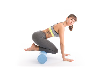 Fototapeta na wymiar Portrait of attractive woman doing exercises. Brunette with fit body on foam roller. Healthy lifestyle and sports concept. Isolated on white.