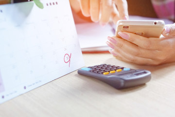  a business woman hand calculating her yearly accounting report of income and expenses with her...