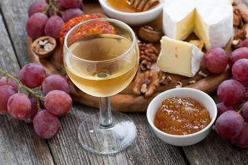 glass of cold white wine and snacks on a wooden background