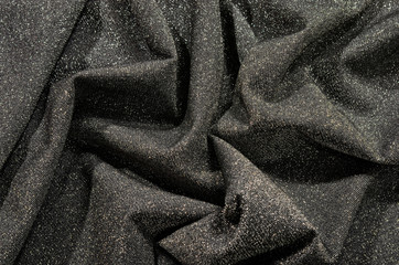 Shiny silver gray folded fabric as background.