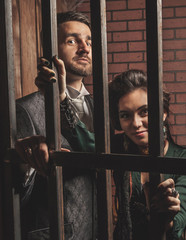 Gentleman and a lady behind bars in the prison.