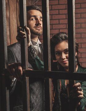 Gentleman and a lady behind bars in the prison.