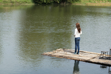 Woman on a bamboo raft in river