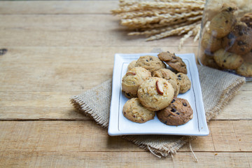 Cookie in white plate on hemp sack on wood table with copy space. vintage tone. Selective focus.