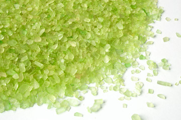 closeup of a green bath salt on white