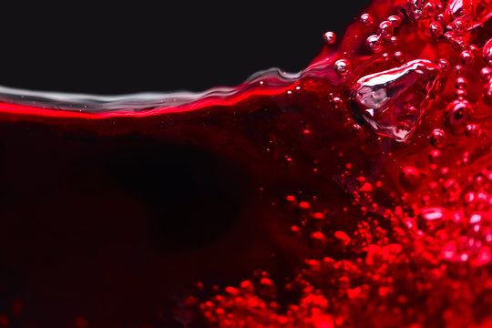 Abstract splashes of red wine on a black background