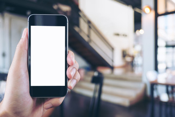Mockup image of hand holding black mobile phone with blank white screen in cafe