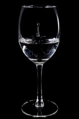 Drop of the water in the glass on the black background