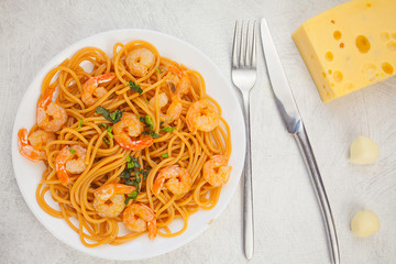 delicious delicious spaghetti with shrimps on wooden background