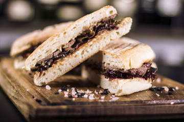 Close up of delicious meat sandwiches. Beautifully served meal at the restaurant. Glass of juice in the background.